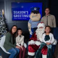 Parents with brother and sister smile with Santa and Louie